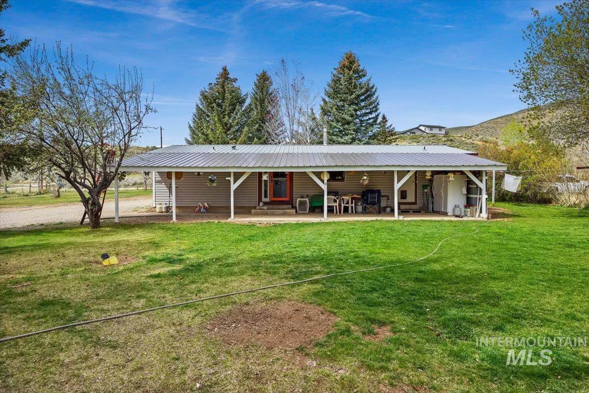 102 Willow Creek Road Fairfield, ID 83327 - Photo 24 of 32 Back of house with a yard, a metal roof, and a porch