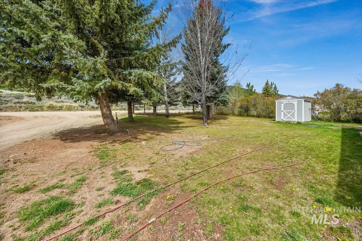 102 Willow Creek Road Fairfield, ID 83327 - Photo 3 of 32 View of grassy yard featuring a storage unit