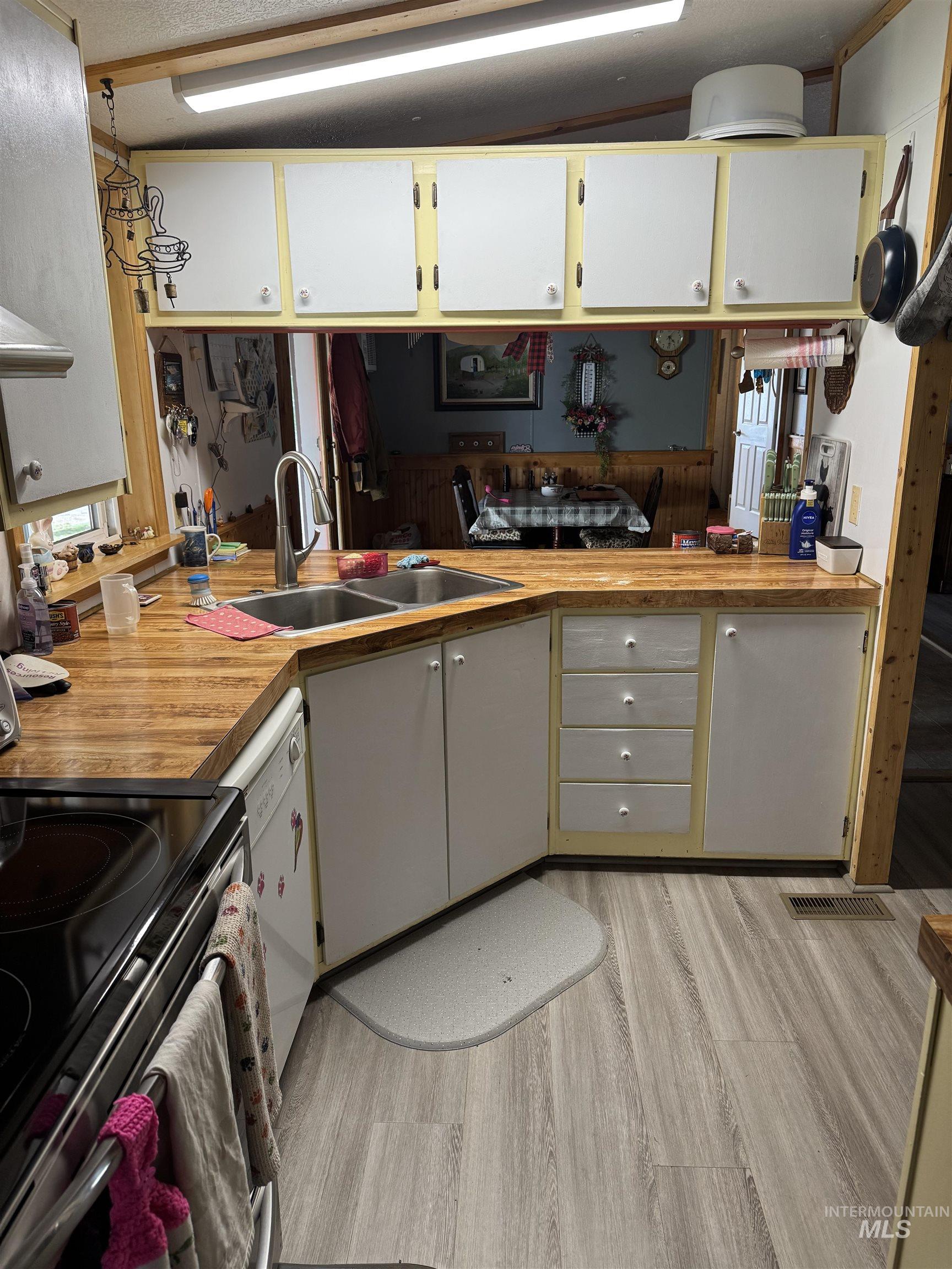 102 Willow Creek Road Fairfield, ID 83327 - Photo 36 of 40 Kitchen with electric range, light wood-style flooring, extractor fan, light countertops, and white dishwasher