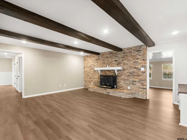 a kitchen with white cabinets appliances and wooden floor