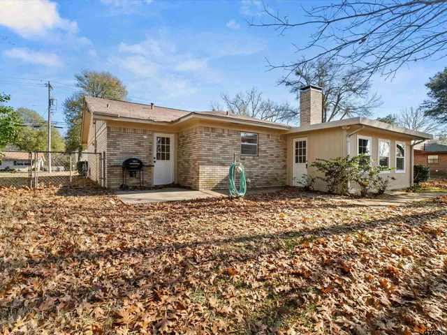 a view of a yard in front of a house with large trees