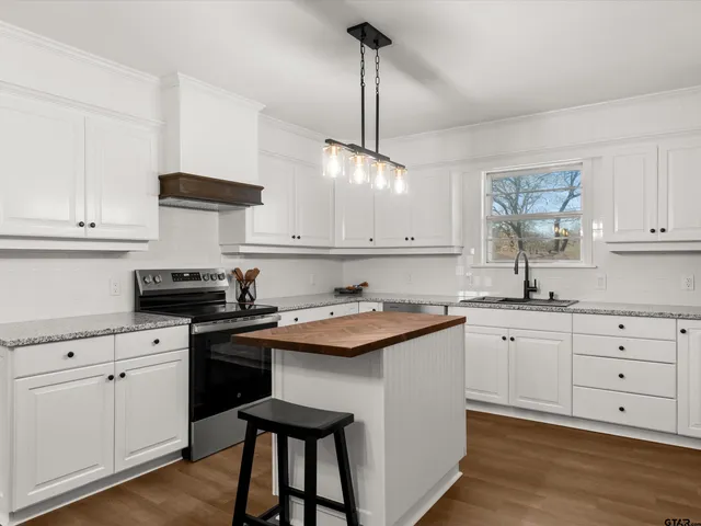 a kitchen with granite countertop white cabinets and white appliances