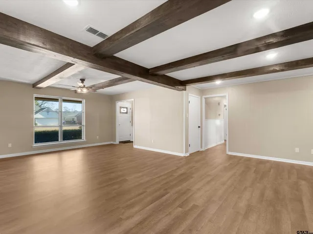 an empty room with wooden floor and fireplace