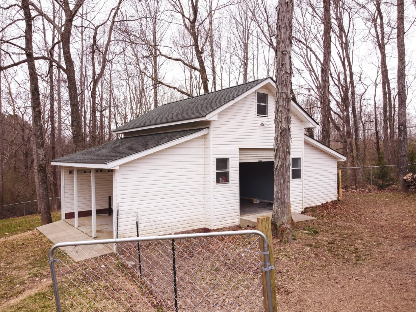 1014 Meeks Cemetery Road Burns, TN 37029 - Photo 31 of 33 a backyard of a house with large trees and wooden fence