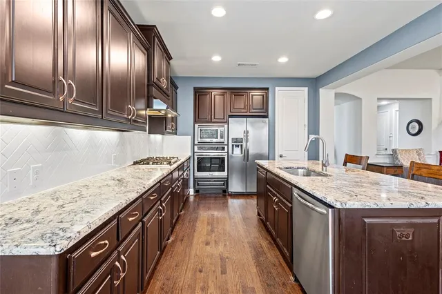 a kitchen with granite countertop stainless steel appliances and wooden cabinets