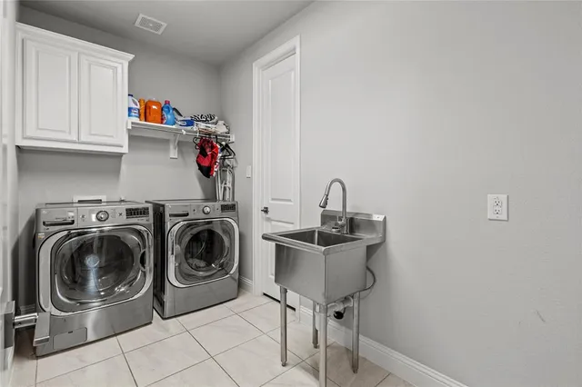 a utility room with sink dryer and washer