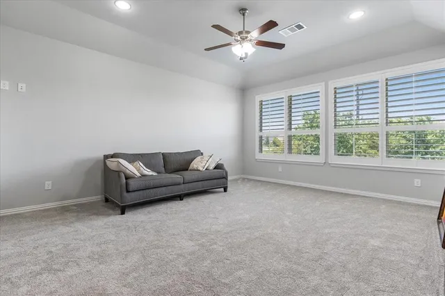 a living room with furniture and a ceiling fan