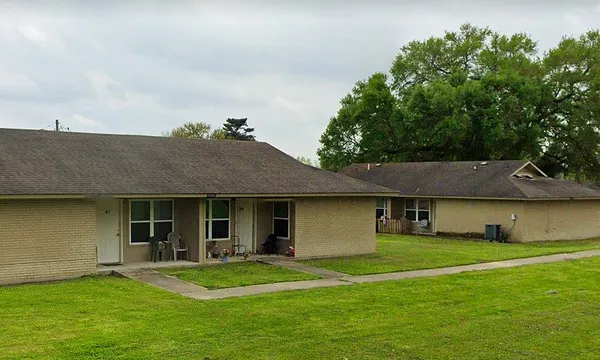a front view of a house with a garden and yard