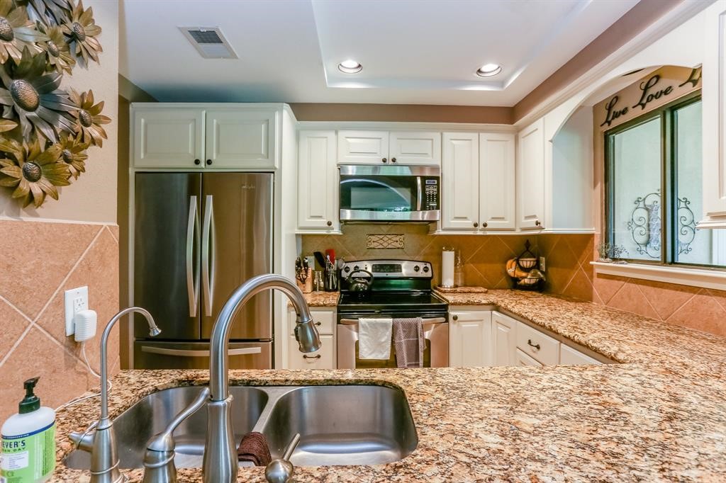 4144 Greystone Way, Unit 306 Sugar Land, TX 77479 - Photo 7 of 11 a kitchen with stainless steel appliances granite countertop a refrigerator a stove a sink and a microwave
