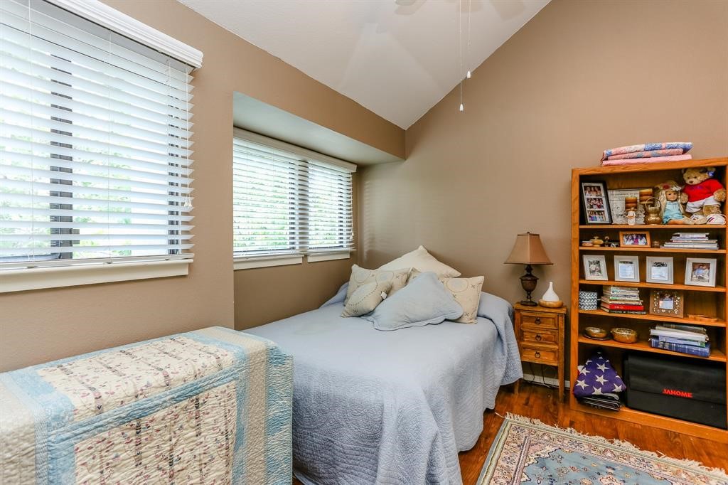 4144 Greystone Way, Unit 306 Sugar Land, TX 77479 - Photo 10 of 11 a bedroom with a bed furniture and a book shelf