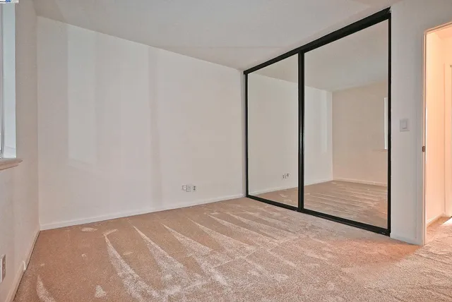 a view of an empty room with window and bathroom