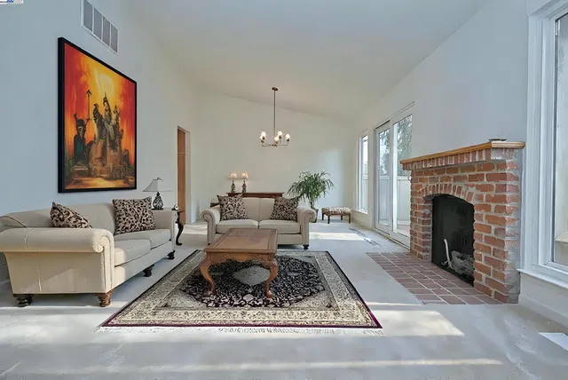 a view of an empty room with a fireplace and a window