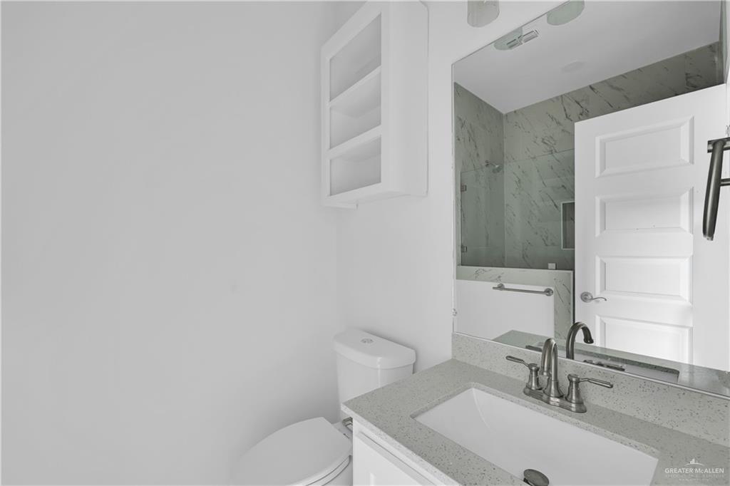11403 North 25th Street, Unit 2 McAllen, TX 78504 - Photo 11 of 14 a bathroom with a sink a toilet and a mirror