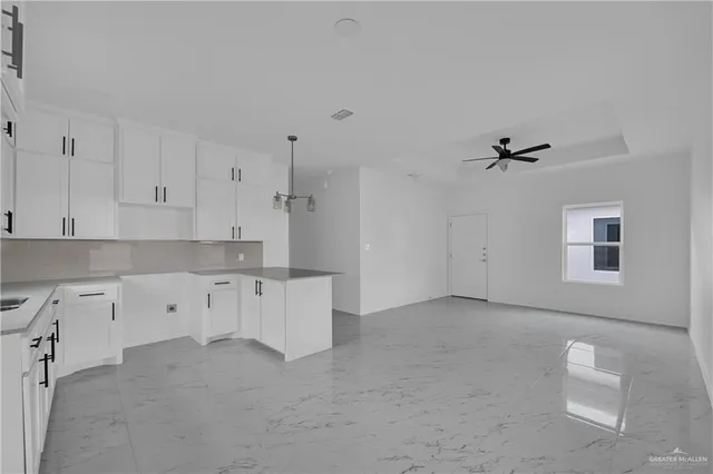 a kitchen with white cabinets and window