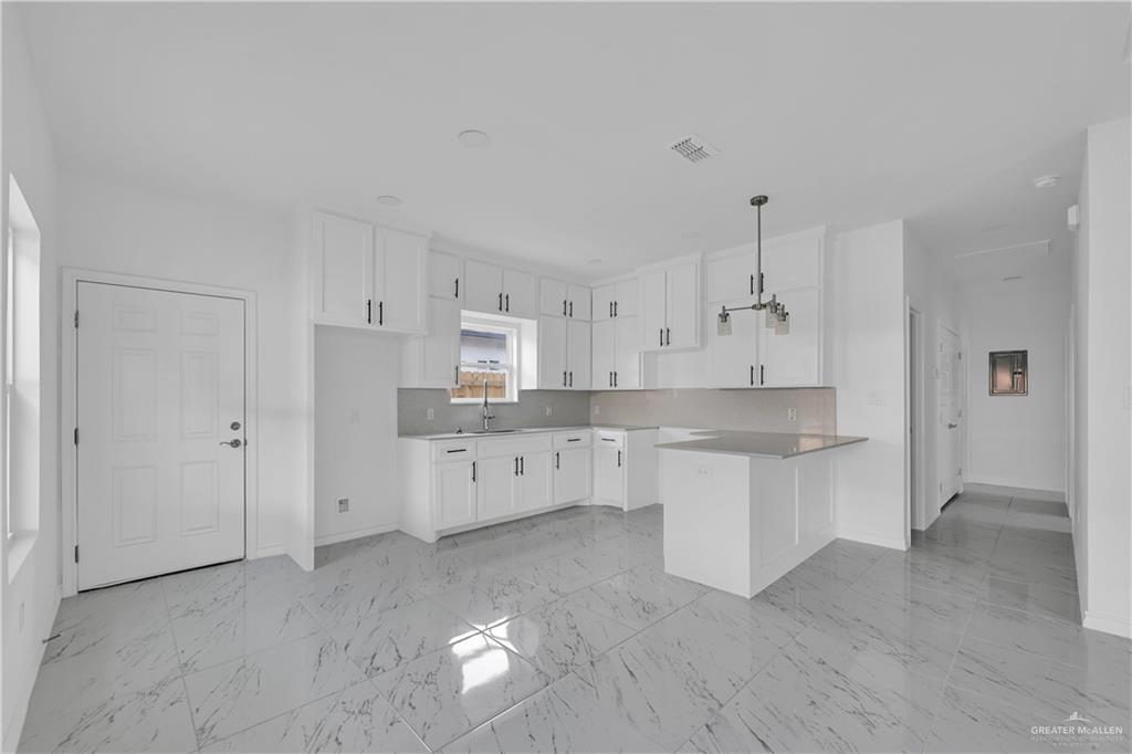 11403 North 25th Street, Unit 2 McAllen, TX 78504 - Photo 5 of 14 a large kitchen with cabinets and wooden floor