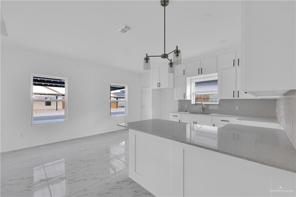 11403 North 25th Street, Unit 2 McAllen, TX 78504 - Photo 6 of 14 a kitchen with granite countertop a sink a counter space appliances and cabinets