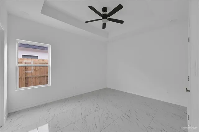an empty room with a window and a fan