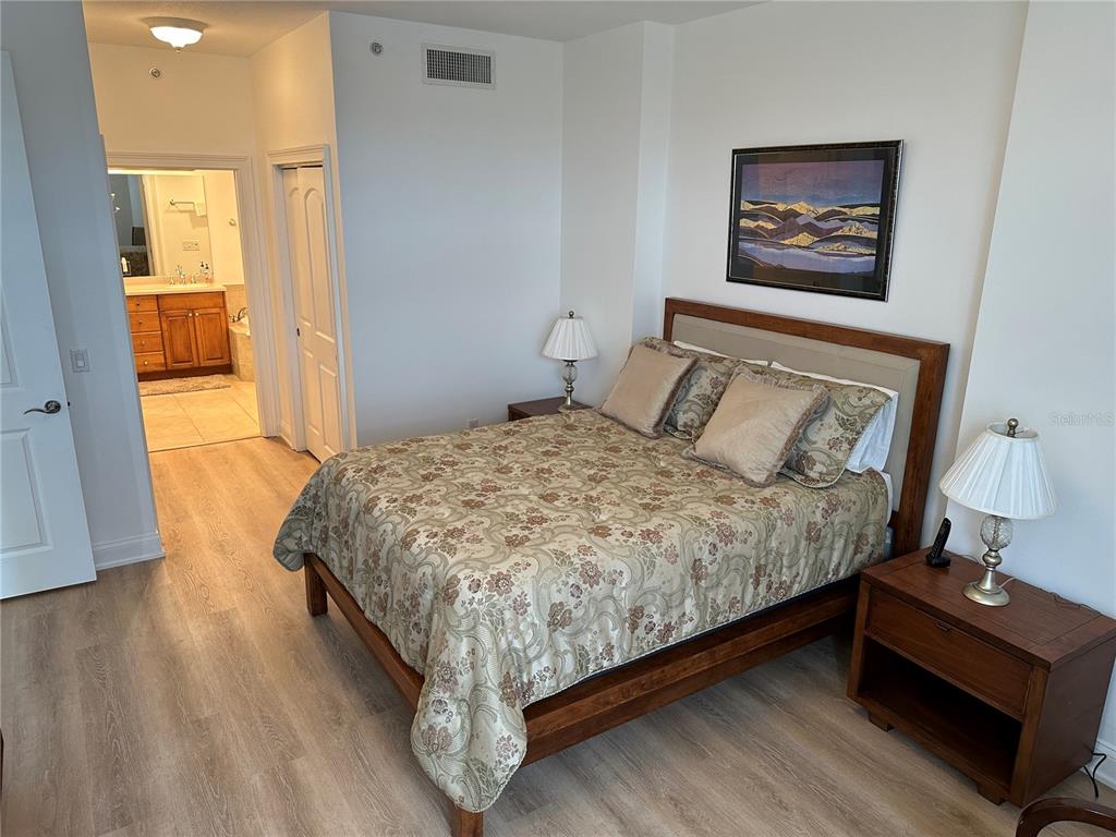 615 Riviera Dunes Way, Unit 406 Palmetto, FL 34221 - Photo 12 of 28 a bedroom with a bed and wooden floor