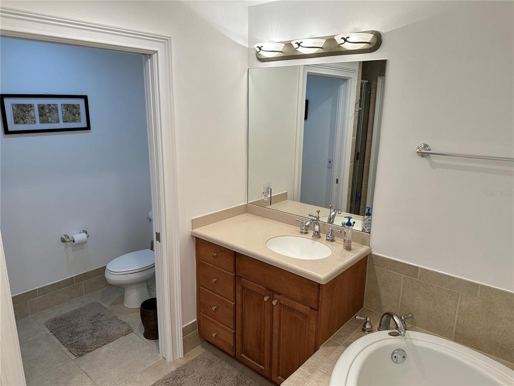 615 Riviera Dunes Way, Unit 406 Palmetto, FL 34221 - Photo 14 of 28 a bathroom with a sink vanity mirror and toilet