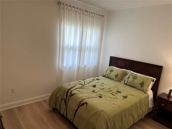 a bed sitting in a bedroom next to a window and dresser