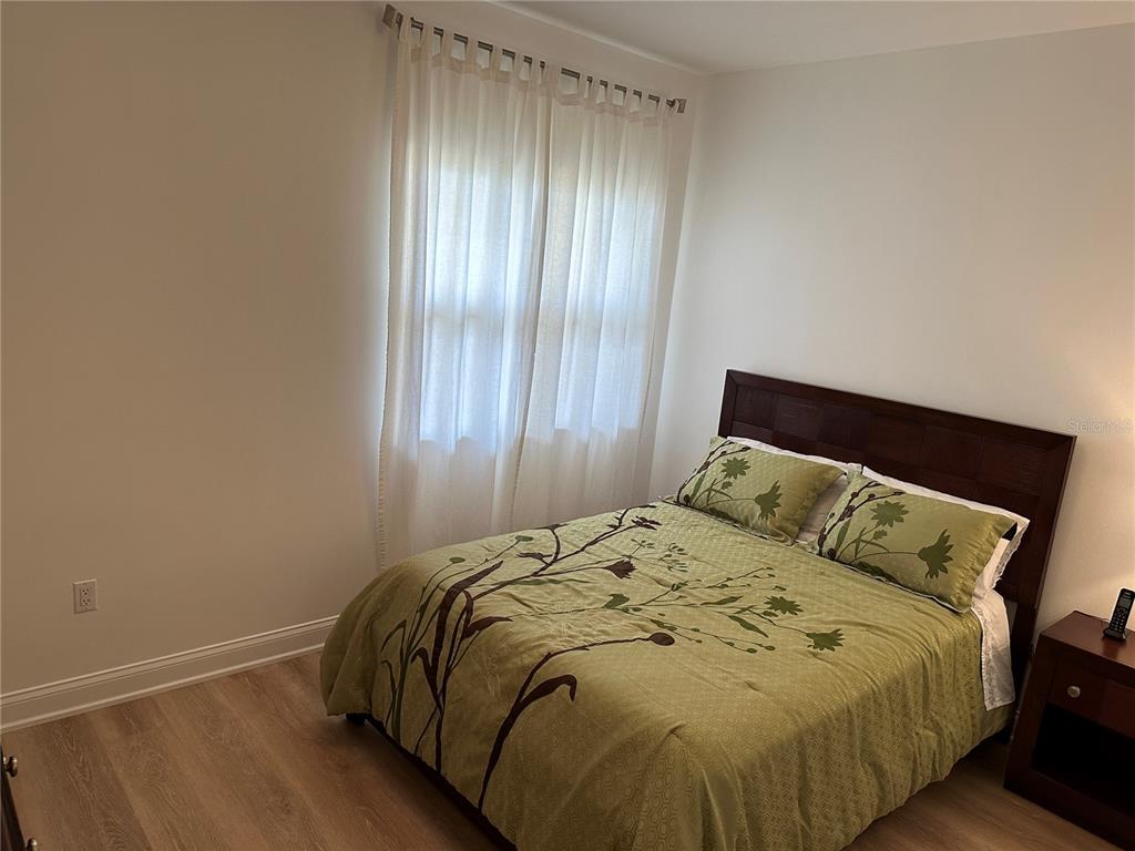 615 Riviera Dunes Way, Unit 406 Palmetto, FL 34221 - Photo 16 of 28 a bed sitting in a bedroom next to a window and dresser