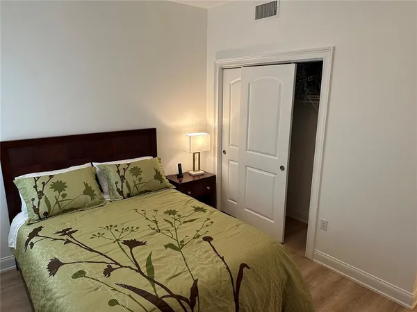 a bed sitting in a bedroom and wooden floor