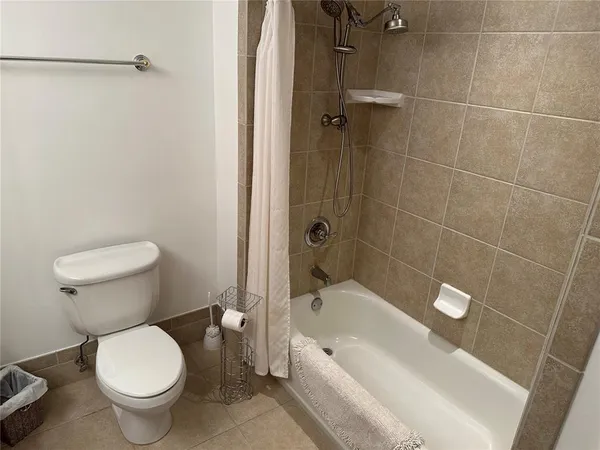 a white toilet sitting next to a bath tub and shower