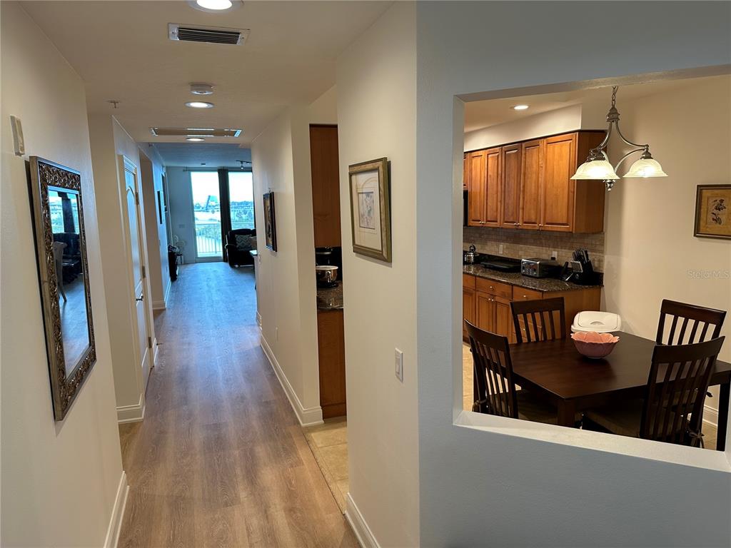 615 Riviera Dunes Way, Unit 406 Palmetto, FL 34221 - Photo 2 of 28 a hallway with dining table and chairs