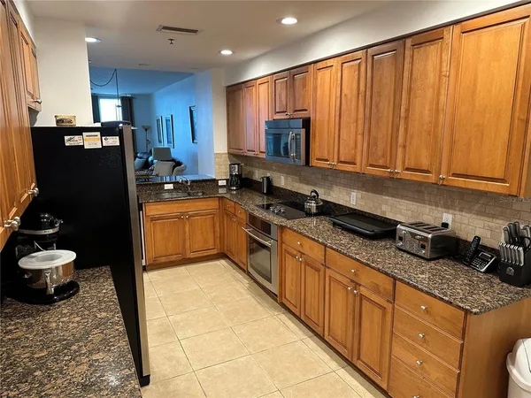 a kitchen with stainless steel appliances granite countertop a stove sink and cabinets