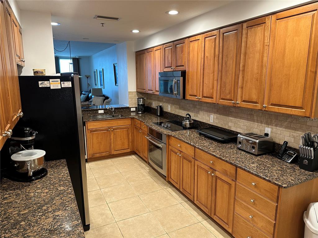 615 Riviera Dunes Way, Unit 406 Palmetto, FL 34221 - Photo 3 of 28 a kitchen with stainless steel appliances granite countertop a stove sink and cabinets