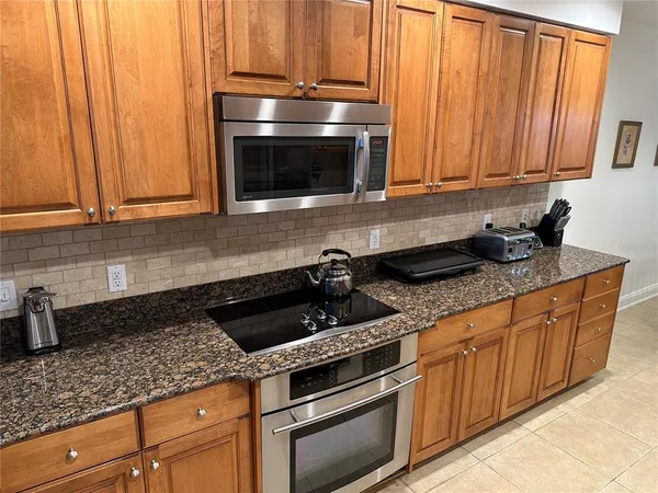 a kitchen with granite countertop stainless steel appliances a stove a microwave and cabinets