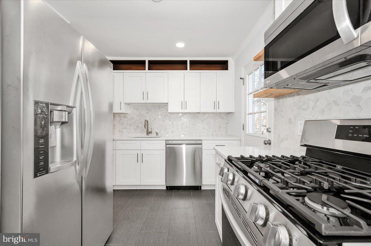 4511 Bennion Road Silver Spring, MD 20906 - Photo 13 of 40 a kitchen with white cabinets and appliances