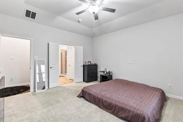 a spacious bedroom with a bed and a chandelier