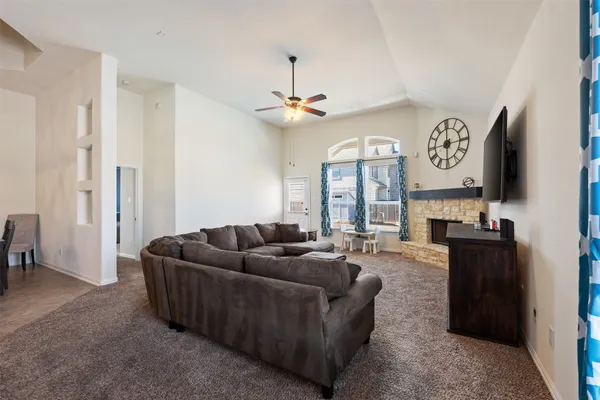 a living room with furniture a chandelier and a flat screen tv
