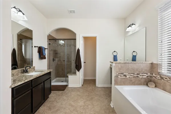 a bathroom with a double vanity sink a mirror and shower