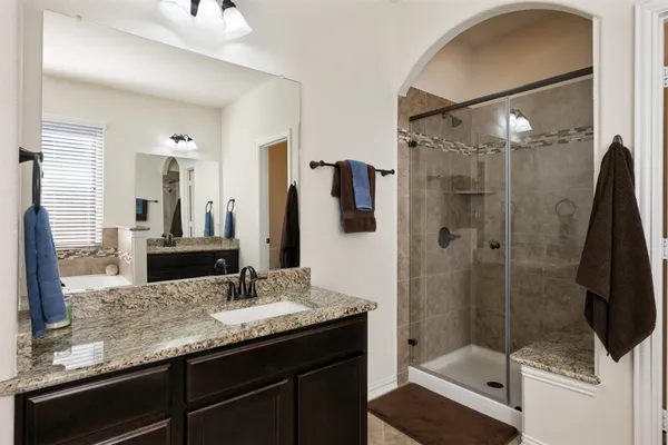 a bathroom with a granite countertop sink mirror and shower