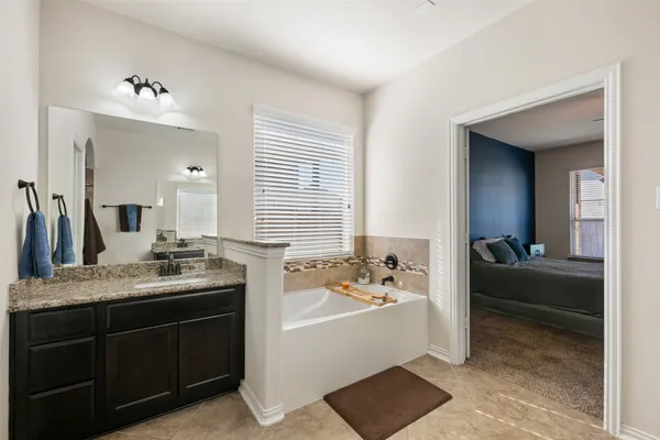 a bathroom with a tub sink and mirror