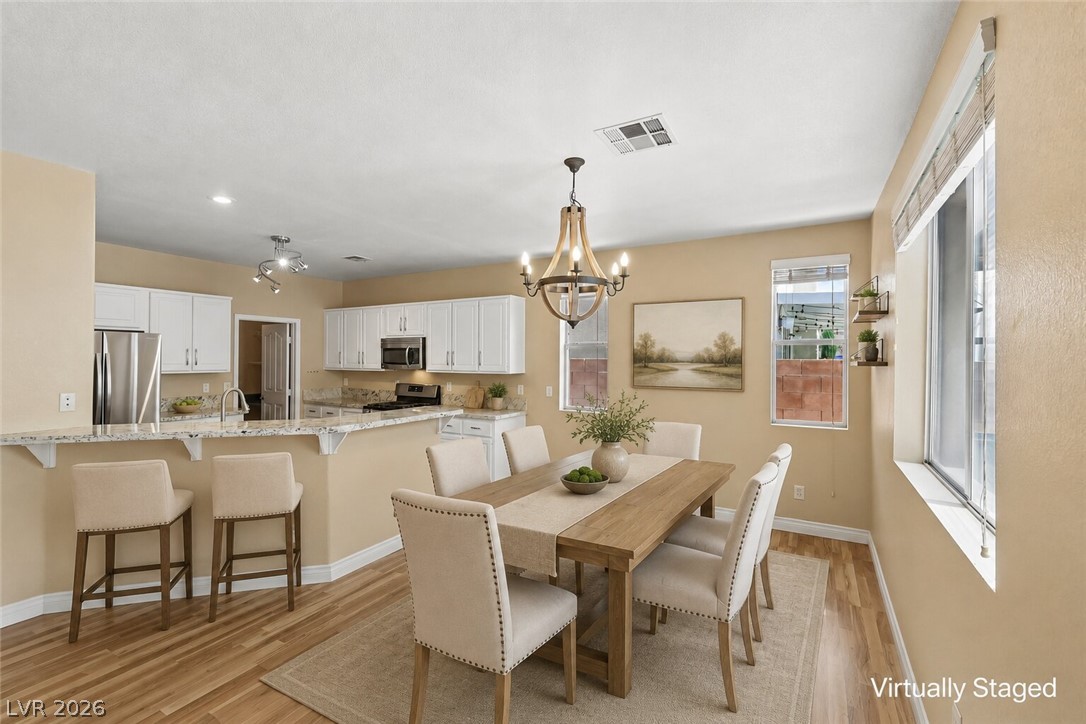 1727 Millstream Way Henderson, NV 89074 - Photo 3 of 46 An open-concept layout unites the dining space and kitchen, ideal for entertaining and daily living.