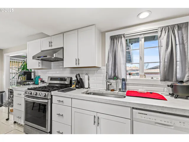 a kitchen that has a sink and a stove in it