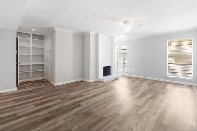 a view of empty room with wooden floor and entryway