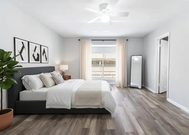 a bedroom with a large bed couch and a window