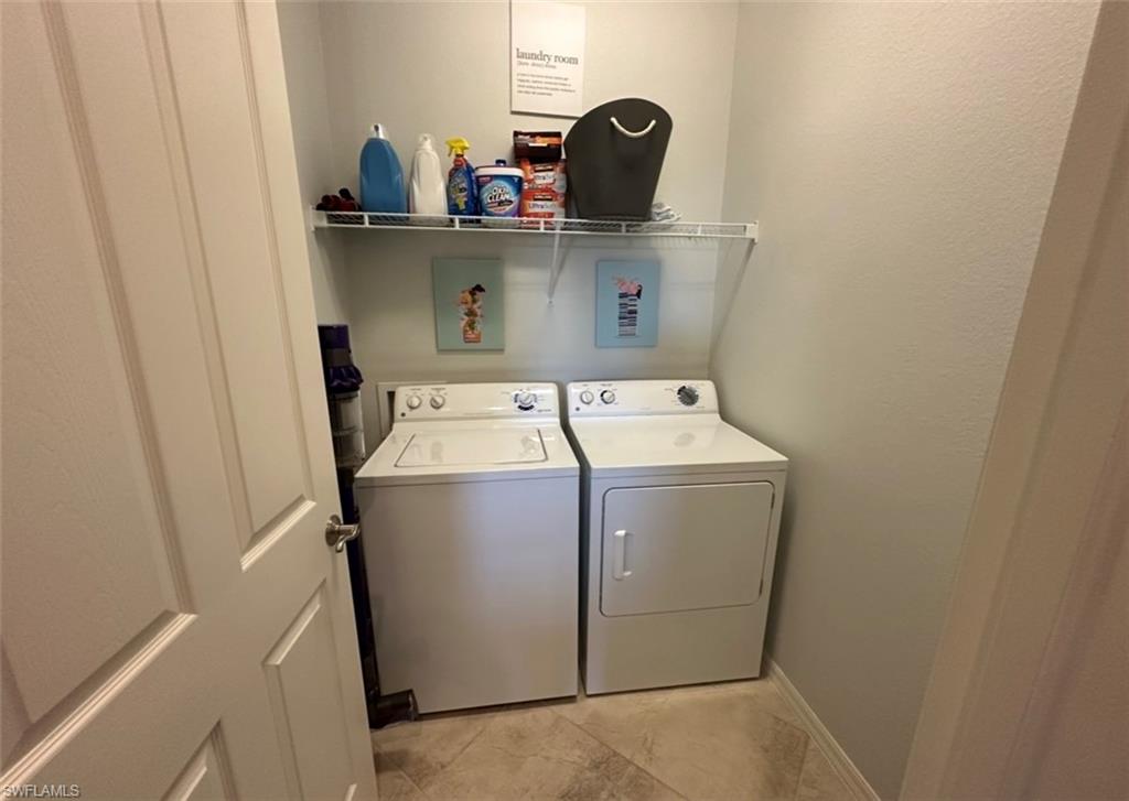 8997 Cambria Circle, Unit 2001 Naples, FL 34113 - Photo 14 of 42 Laundry room featuring washing machine and clothes dryer, baseboards, and laundry area