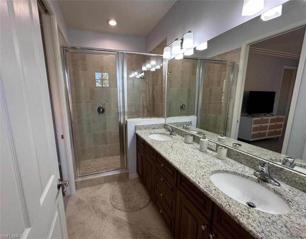 8997 Cambria Circle, Unit 2001 Naples, FL 34113 - Photo 16 of 42 Full bathroom with double vanity, a sink, and a shower stall