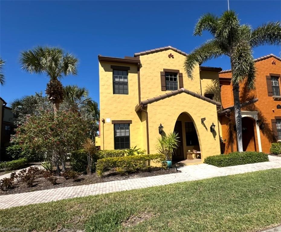 8997 Cambria Circle, Unit 2001 Naples, FL 34113 - Photo 2 of 42 Mediterranean / spanish home featuring a front lawn and stucco siding