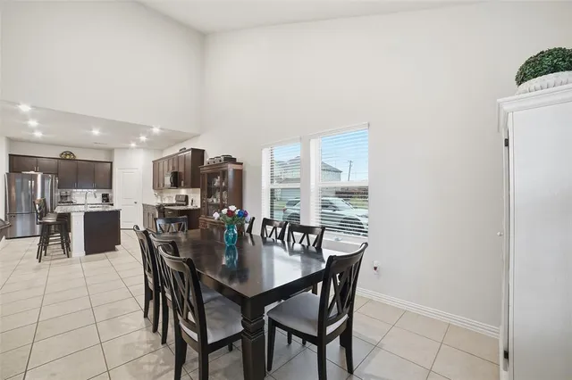a dining room with furniture and a floor to ceiling window