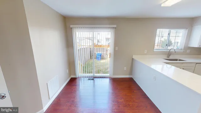 a view of a kitchen with wooden floor and a window