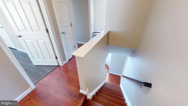 an empty room with wooden floor and a bathroom