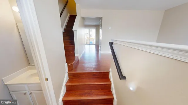 a view of staircase with wooden floor and white walls