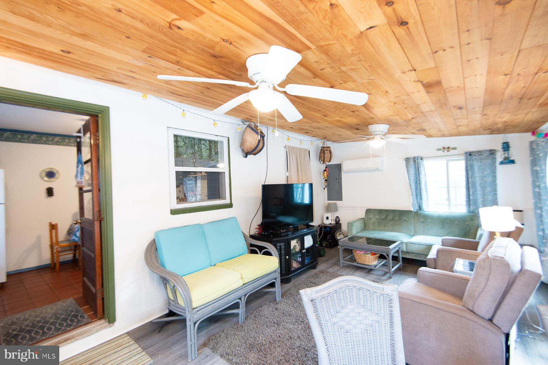 819 Seabreeze Road Cambridge, MD 21613 - Photo 19 of 31 a living room with furniture a ceiling fan a rug and a window