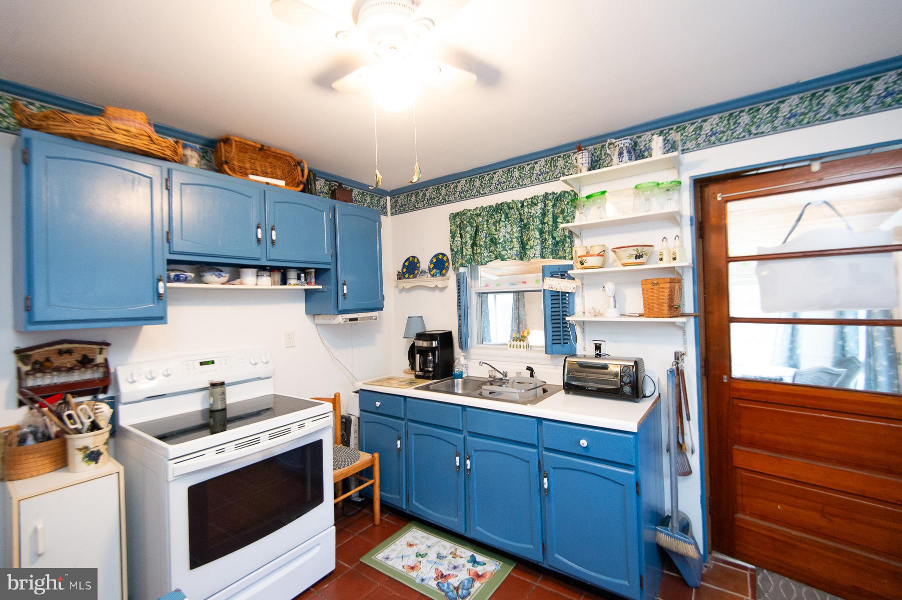819 Seabreeze Road Cambridge, MD 21613 - Photo 9 of 31 a kitchen with wooden cabinets and a stove top oven